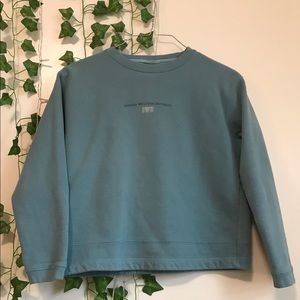 Indiana Wesleyan University teal crew neck. Size medium. Some signs of wear.